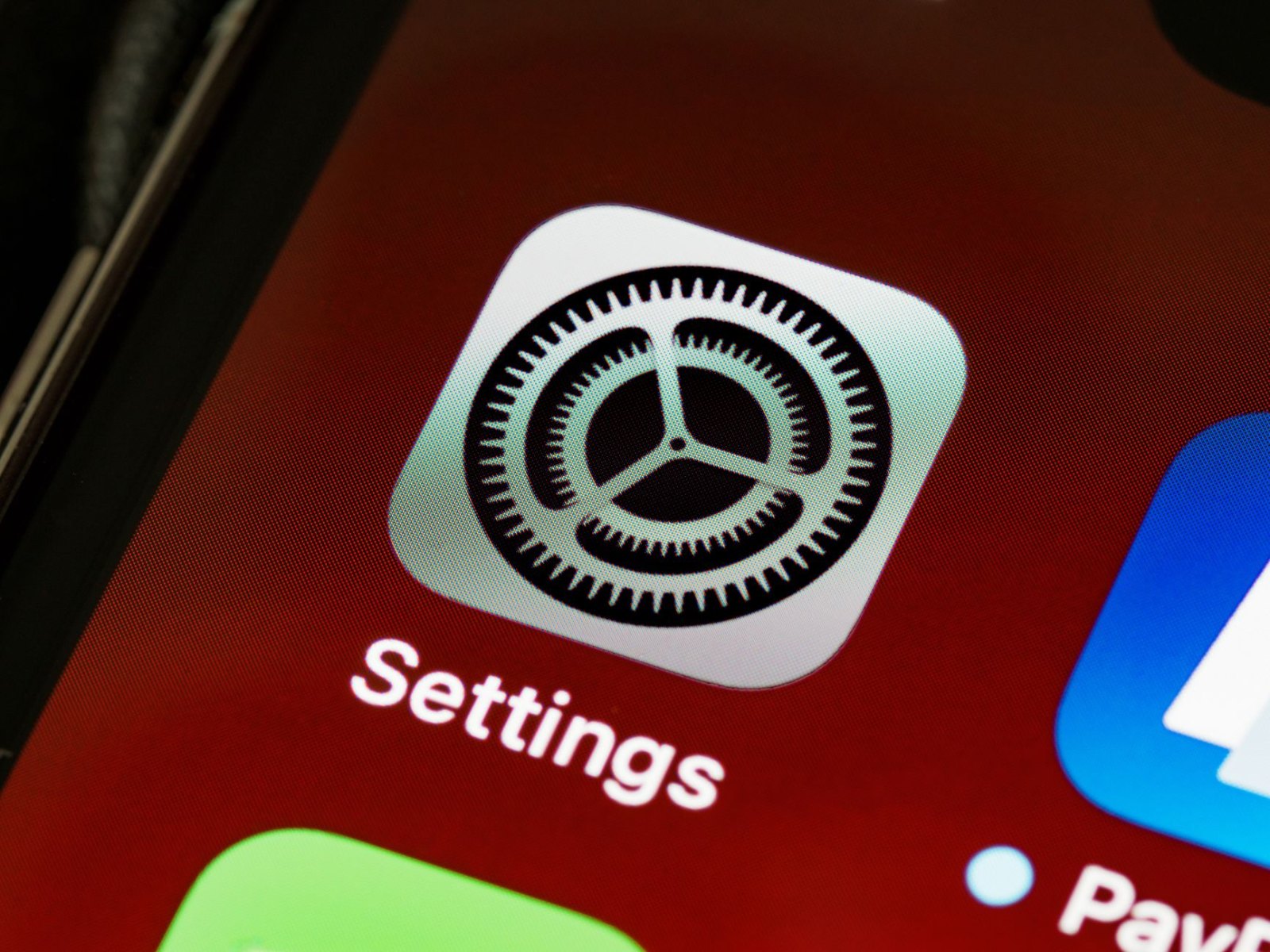 Экран настроек аккумулятора iPhone с графиком расхода заряда, телефон на зарядке у окна